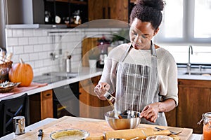 African american woman preparing pumpkin pie for holidays photo
