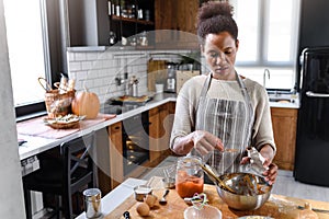 African american woman preparing pumpkin pie for holidays photo