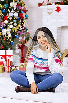 African american woman Put up a Christmas tree and make New Year decorations. Xmas background. Happy excited girl at home