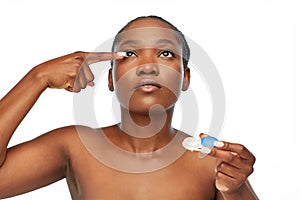 African american woman putting on contact lenses