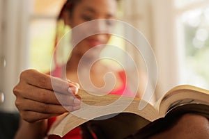 African American Woman Reading Book At Home Focus On Hand