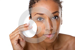 African american woman removing makeup with sponge