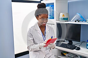 African american woman scientist using touchpad working at laboratory