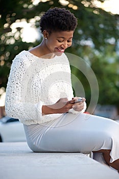 African american woman sending text message with cellphone