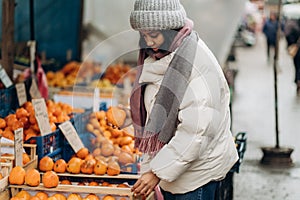 An African American woman is shopping at a local street market. He also chooses fresh fragrant fruits.