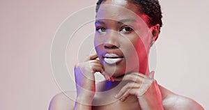 African american woman with short dark hair in blue and pink light with copy space, slow motion