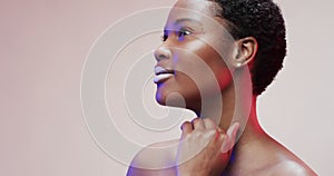 African american woman with short dark hair in blue and pink light with copy space, slow motion