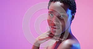 African american woman with short dark hair in blue and pink light with copy space, slow motion