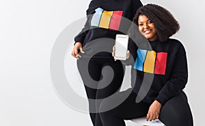 African american woman showing blank phone screen, mockup