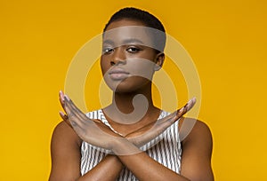 African american woman showing stop sign with arms crossed