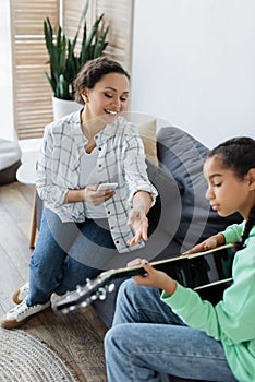 african american woman with smartphone pointing