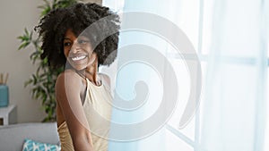 African american woman smiling confident opening curtain at home