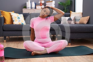 African american woman smiling confident stretching head at home
