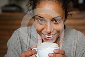 African american woman smiling with cup of a coffee