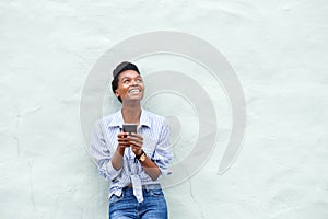 African american woman smiling with mobile phone and looking up