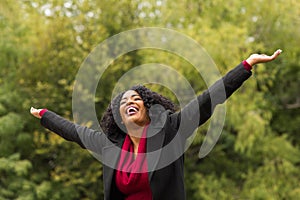 African American woman smiling with open arms.