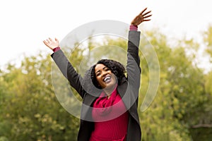 African American woman smiling with open arms.
