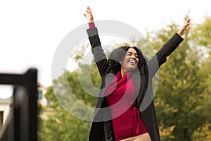 African American woman smiling with open arms.