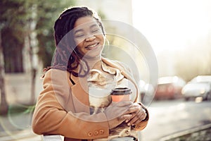 African american woman standing in a srteet with takeaway coffee cup photo