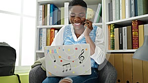 African american woman student using laptop studying at library university
