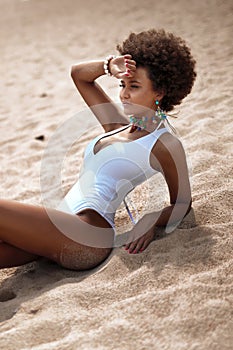 African american woman sunbathing on the sandy beach