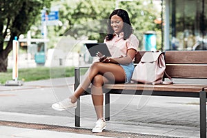 african american woman with tablet pc in city