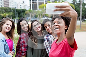 African american woman taking selfie with group of international