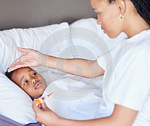 African american woman taking temperature of her son. Mother using thermometer to measure sons temperature. Sick little