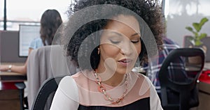 African american woman talking on phone headset sitting on her desk at office