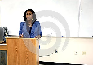 African American Woman teaching students in a college classroom