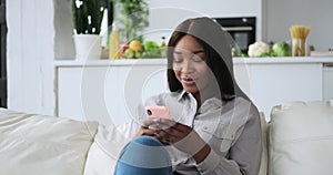 African American woman text messaging using mobile phone