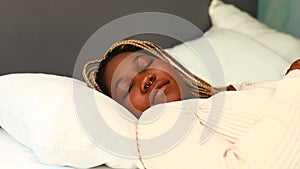 african american woman trying to sleep but the pillow is not comfortable
