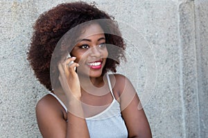 African american woman with typical afro hair at phone