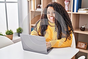 African american woman using laptop sitting on table at home