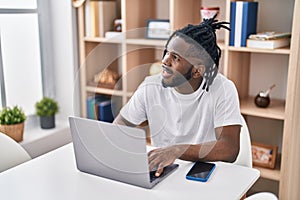 African american woman using laptop sitting on table at home