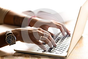 African American woman using laptop, typing on keyboard, close u