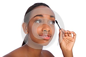 African American woman using mascara brush