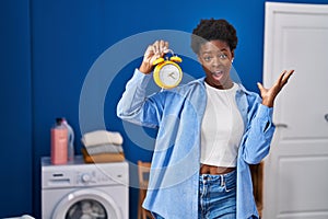 African american woman waiting for laundry celebrating victory with happy smile and winner expression with raised hands