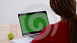 African American woman waving hand in front of laptop screen at table in apartment interior spbi.