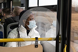African american woman wear medical mask, travel in public transport, bus in new normality of covid