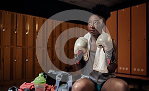 African-american  woman wearing  boxer  gloves for exercise at changing room