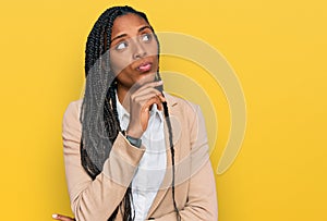 African american woman wearing business jacket with hand on chin thinking about question, pensive expression