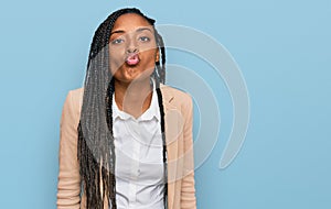 African american woman wearing business jacket looking at the camera blowing a kiss on air being lovely and sexy