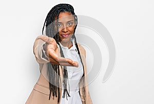 African american woman wearing business jacket smiling cheerful offering palm hand giving assistance and acceptance