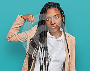 African american woman wearing business jacket strong person showing arm muscle, confident and proud of power