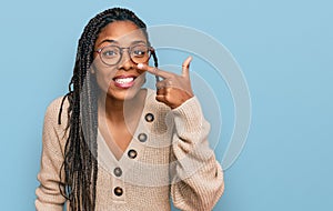 African american woman wearing casual clothes pointing with hand finger to face and nose, smiling cheerful