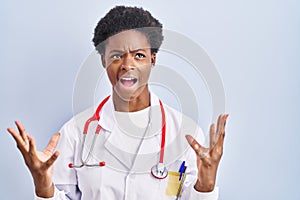 African american woman wearing doctor uniform and stethoscope crazy and mad shouting and yelling with aggressive expression and