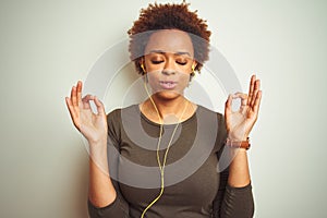 African american woman wearing earphones listening to music over isolated background relax and smiling with eyes closed doing