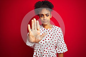 African american woman wearing fashion white dress standing over isolated red background doing stop sing with palm of the hand