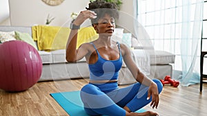 African american woman wearing sportswear stretching head at home